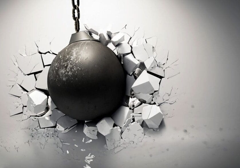 Wrecking ball shattering the white wall